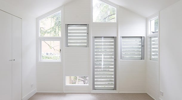 The shutters on these east-facing windows prevent summer overheating of the bedroom, but are easily opened from the inside to allow in winter sunlight. 